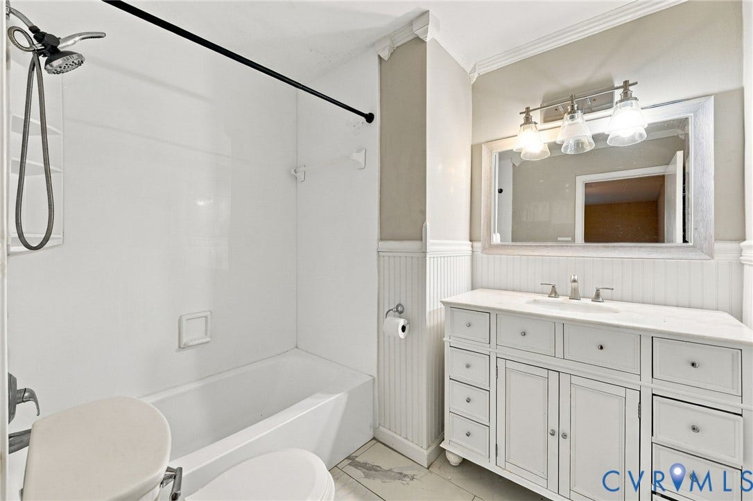 3238 E Weyburn Road, Bon Air, Richmond, VA 23235 White vanity with ample storage drawers, framed mirror, and a three-light fixture