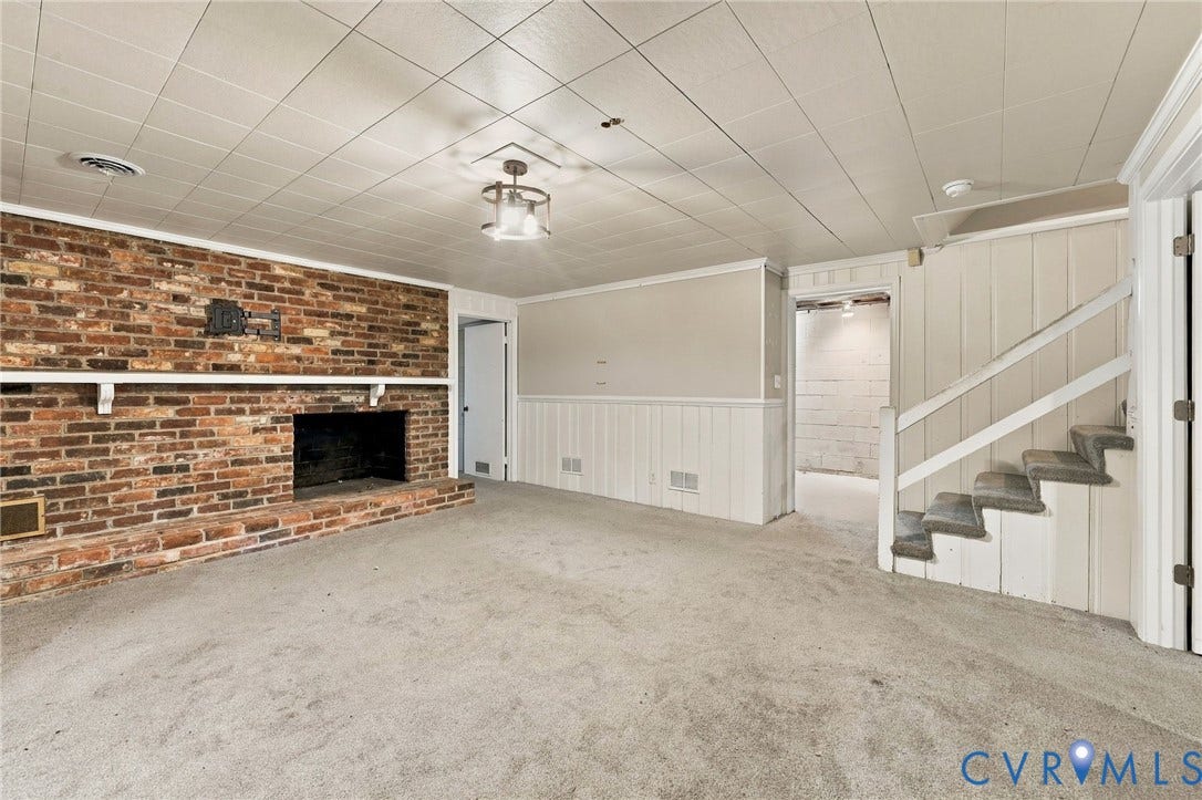 3238 E Weyburn Road, Bon Air, Richmond, VA 23235 Brick fireplace with a hearth, carpeted flooring, drop ceiling, and wainscoting