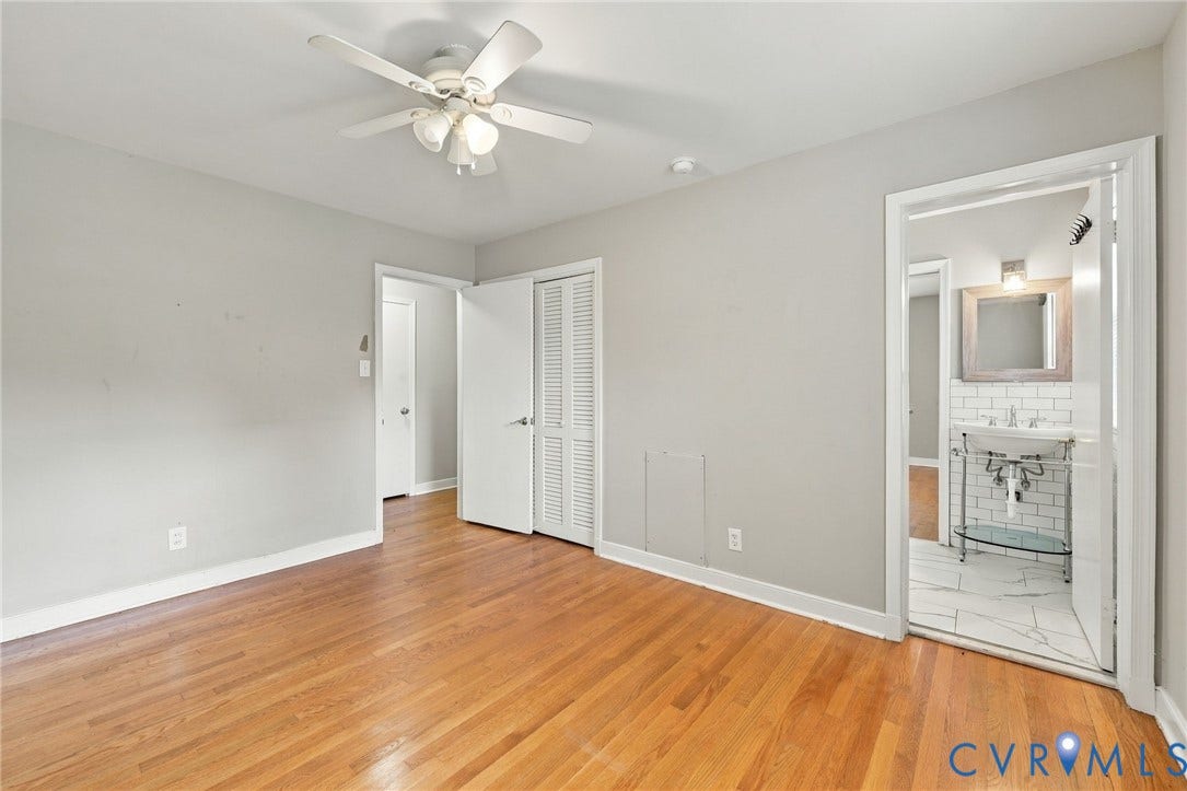 3238 E Weyburn Road, Bon Air, Richmond, VA 23235 Hardwood flooring, ceiling fan, white paneled doors, white bi-fold closet doors, and access to a bathroom with a pedestal sink and subway tile