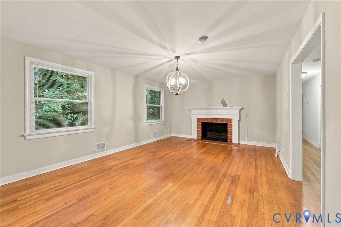 3238 E Weyburn Road, Bon Air, Richmond, VA 23235 Hardwood flooring, brick fireplace with white mantel, two windows with white trim, and a decorative ceiling fixture