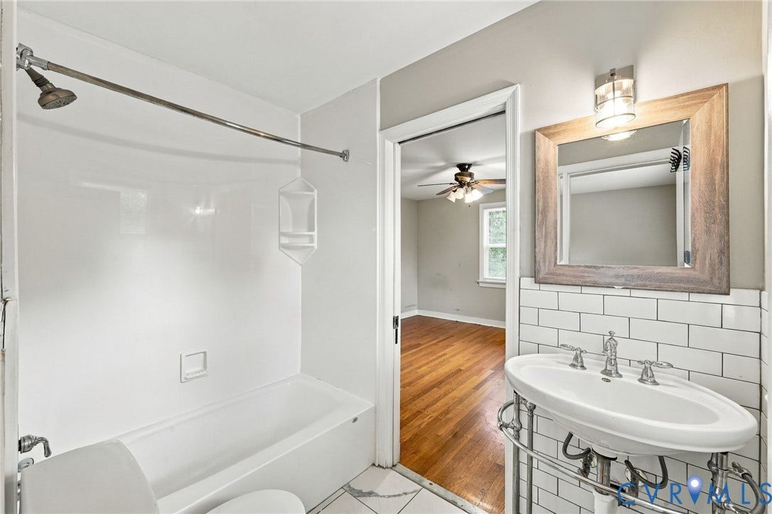 3238 E Weyburn Road, Bon Air, Richmond, VA 23235 Bathroom featuring a white subway tile backsplash, a pedestal sink with chrome fixtures, a framed mirror, and a full bathtub with shower
