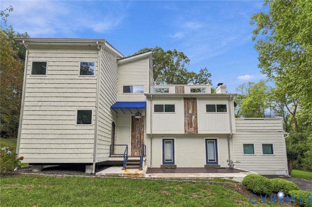 5824 Riverside Drive, Richmond, VA 23225 Multi-level exterior with white siding, a blue awning, and an outdoor patio area