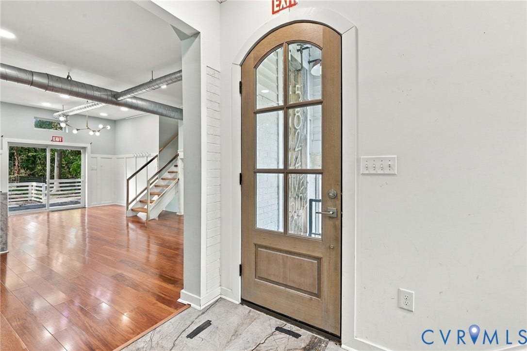 5824 Riverside Drive, Richmond, VA 23225 Arched wooden entry door with glass panels, polished wood flooring, exposed ductwork, and a modern chandelier