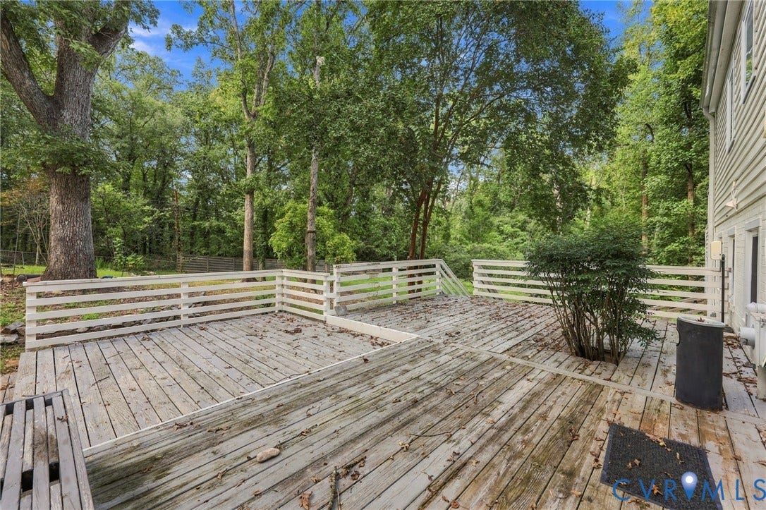 5824 Riverside Drive, Richmond, VA 23225 Expansive wooden deck with a built-in planter, bordered by white perimeter fencing