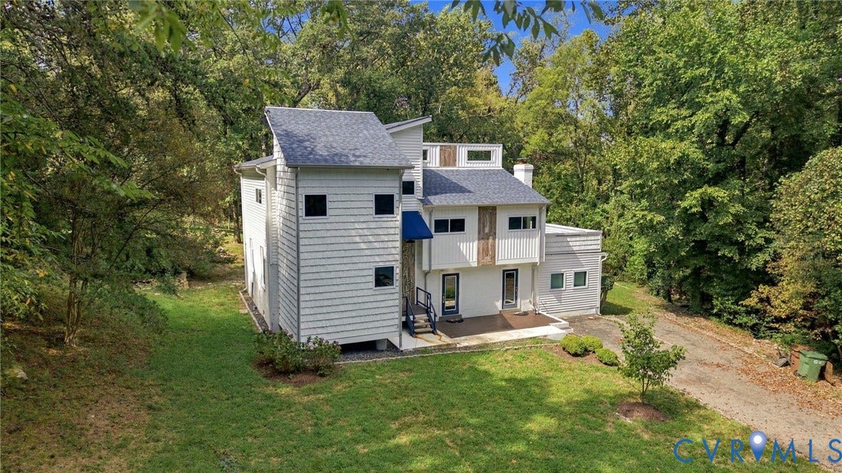 5824 Riverside Drive, Richmond, VA 23225 Multi-level contemporary home featuring white siding, a dark shingle roof, and a blue awning