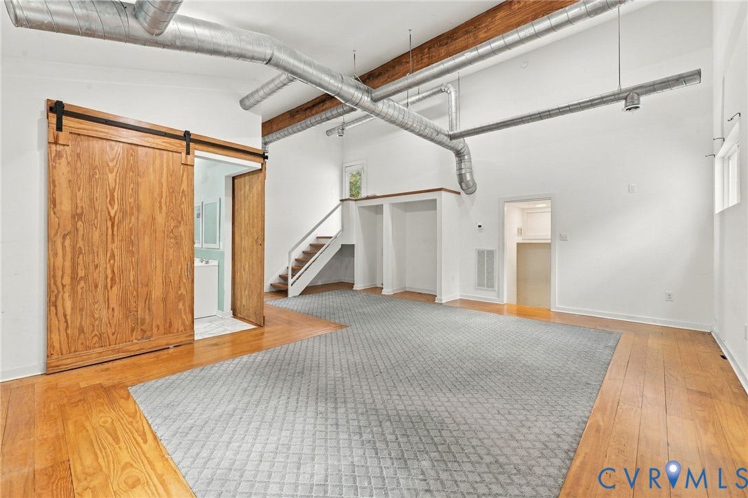 5824 Riverside Drive, Richmond, VA 23225 Exposed wood beams, high ceilings, wood-finish flooring, industrial-style ductwork, and a natural wood barn door
