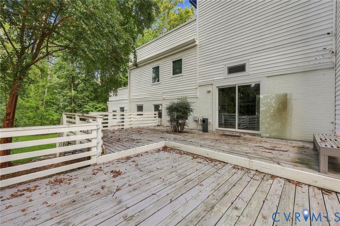 5824 Riverside Drive, Richmond, VA 23225 Expansive outdoor deck with a white painted railing, providing access via sliding glass doors to the white-sided exterior