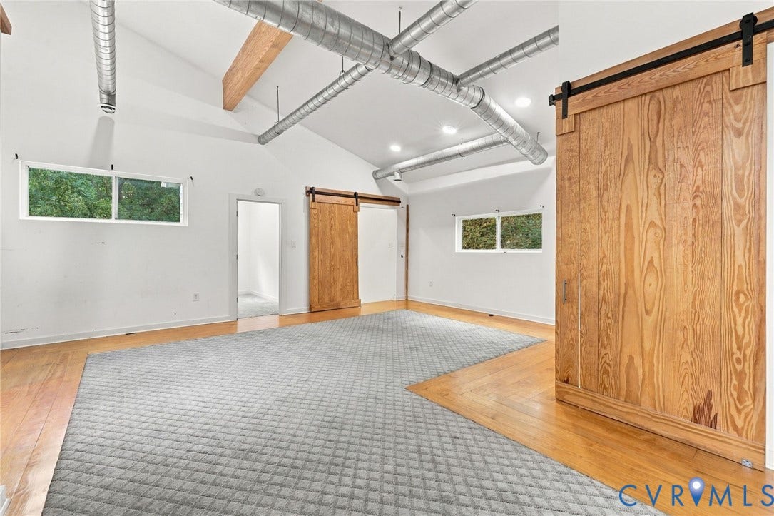 5824 Riverside Drive, Richmond, VA 23225 Vaulted ceilings, exposed ductwork, natural wood-finish flooring, and natural wood barn doors