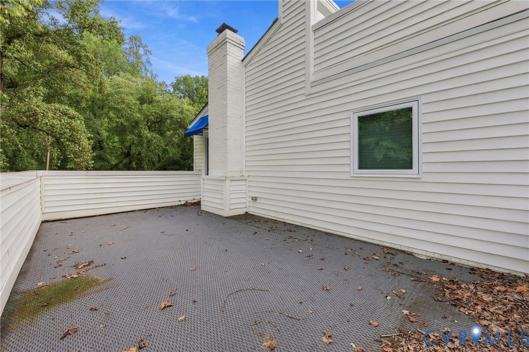 5824 Riverside Drive, Richmond, VA 23225 Private outdoor patio area with a textured surface, surrounded by privacy fencing and a white siding exterior