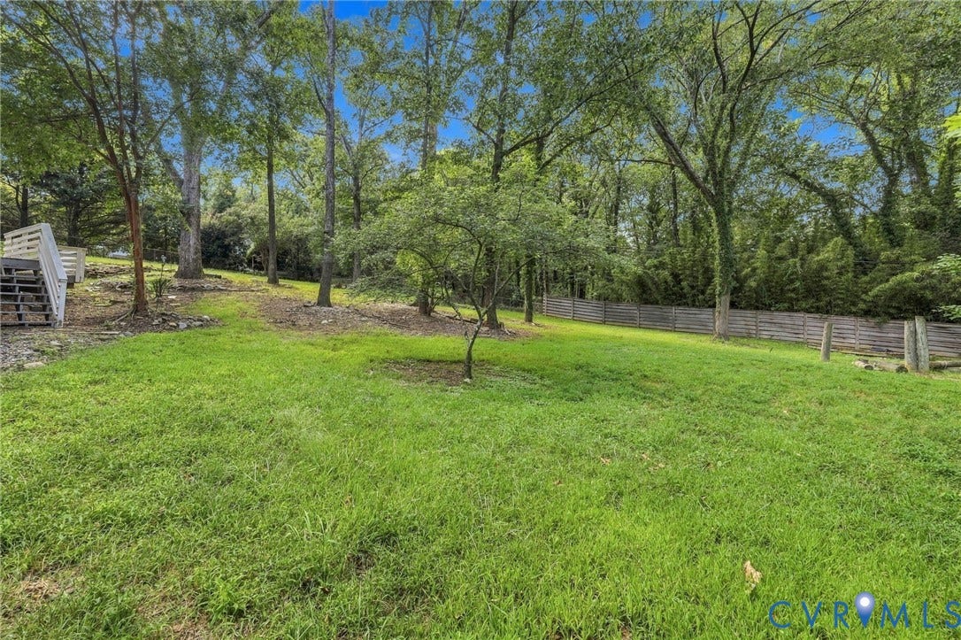 5824 Riverside Drive, Richmond, VA 23225 Expansive lawn area with mature trees, a small tree, and a wood fence