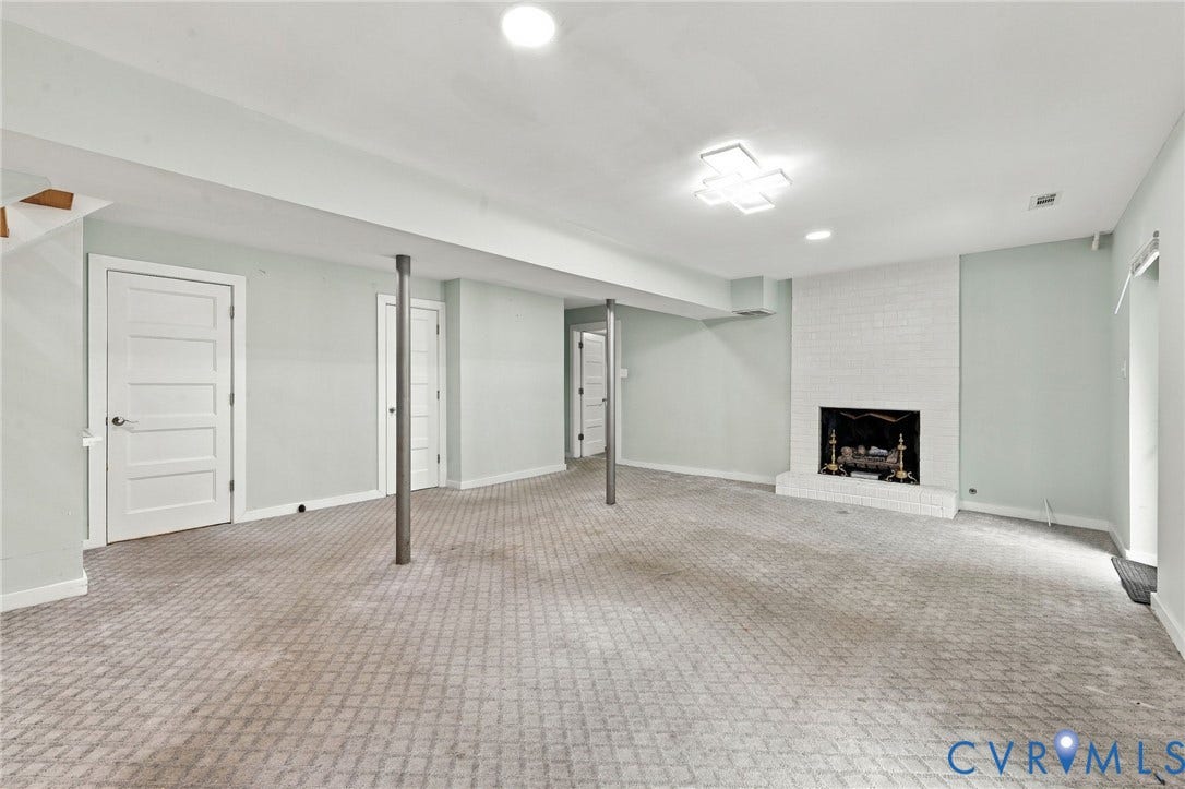 5824 Riverside Drive, Richmond, VA 23225 Spacious lower level featuring patterned carpeting, a white brick fireplace, multiple solid panel doors, and recessed lighting