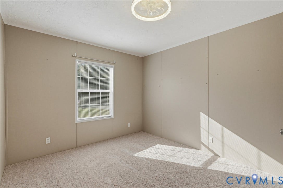 1385 Waltons Store Road, Hadensville North, Louisa, VA 23093 Bright, light-filled bedroom featuring neutral wall finishes, carpet flooring, and a large double-hung window with natural light