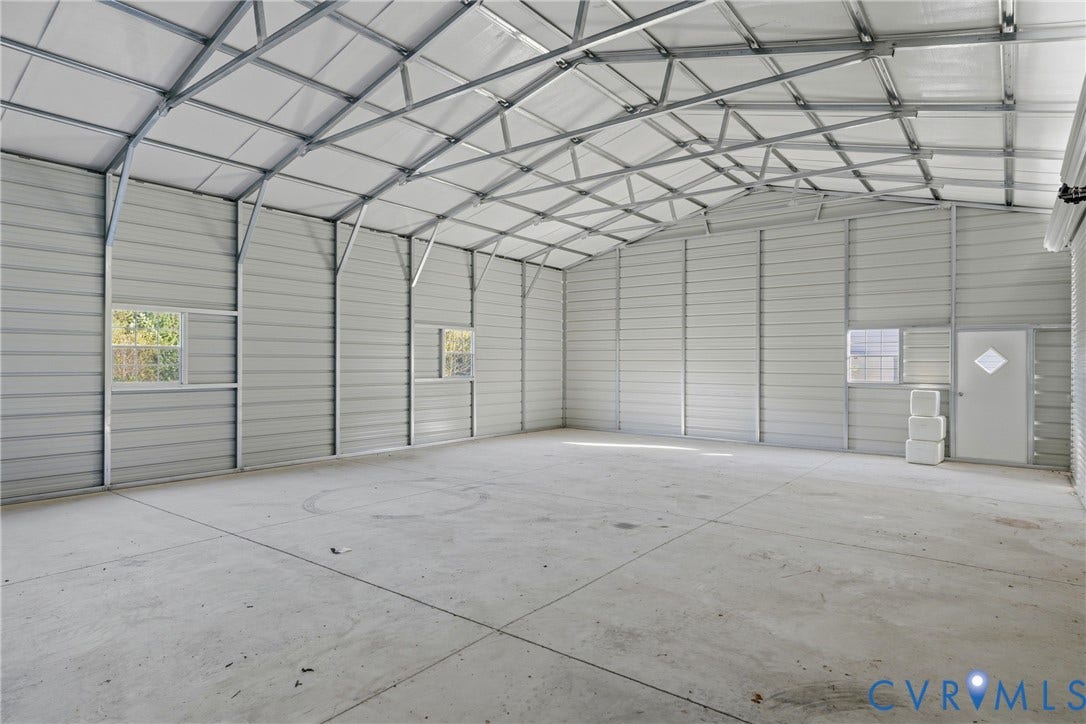 1385 Waltons Store Road, Hadensville North, Louisa, VA 23093 Spacious interior featuring a concrete floor, corrugated metal walls, exposed metal framing, multiple windows, and a side entry door