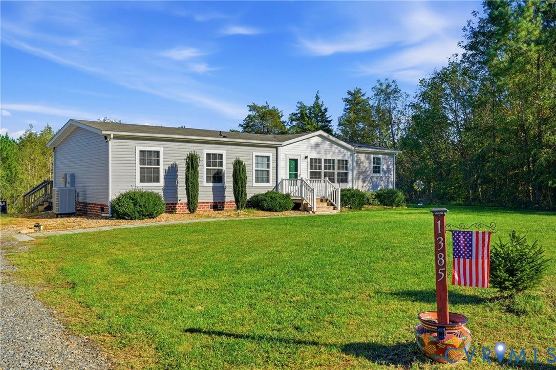 1385 Waltons Store Road, Hadensville North, Louisa, VA 23093 Light gray siding exterior with white trim windows, white porch railing, and an expansive green lawn