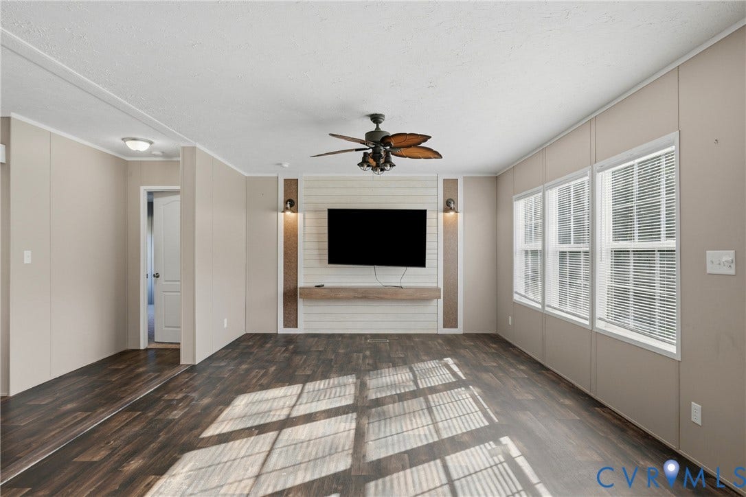 1385 Waltons Store Road, Hadensville North, Louisa, VA 23093 Spacious living area featuring wood-finish flooring, multiple windows with blinds, and a ceiling fan