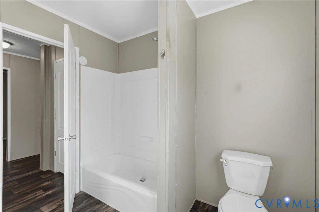 1385 Waltons Store Road, Hadensville North, Louisa, VA 23093 White shower-tub combination with a single built-in shelf, adjacent to a white toilet
