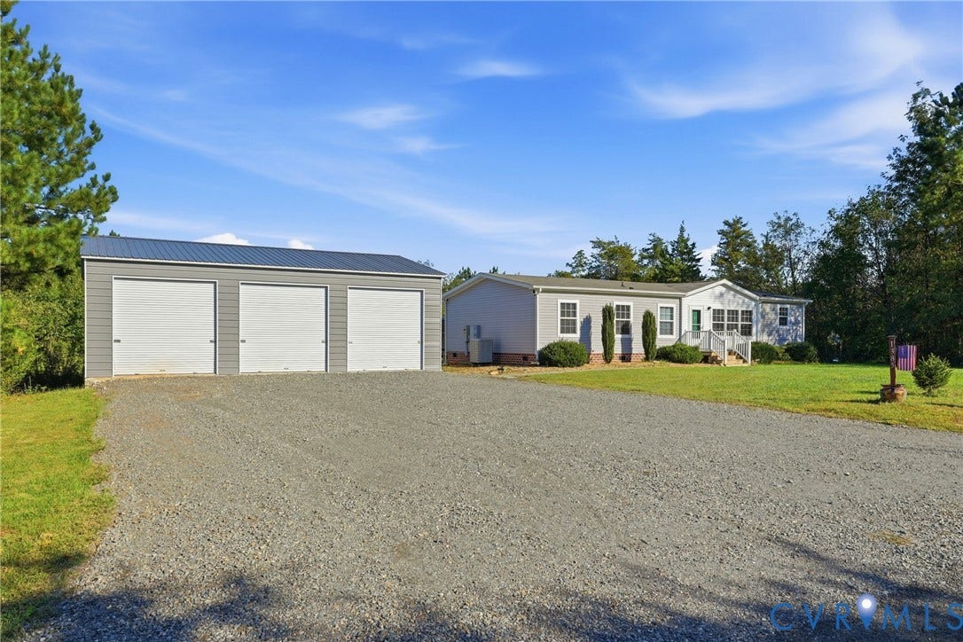 1385 Waltons Store Road, Hadensville North, Louisa, VA 23093 Gravel driveway leading to a three-bay detached garage with metal siding and a metal roof