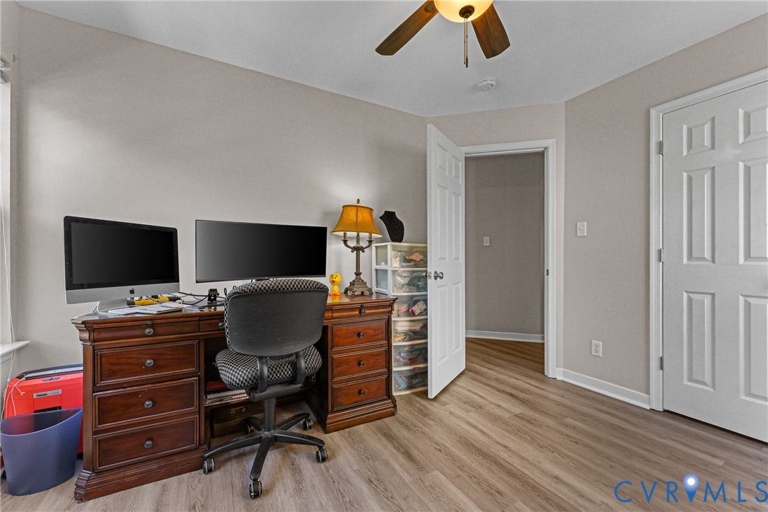 Wood-finish flooring, ceiling fan with integrated lighting, paneled interior doors, and neutral wall tones