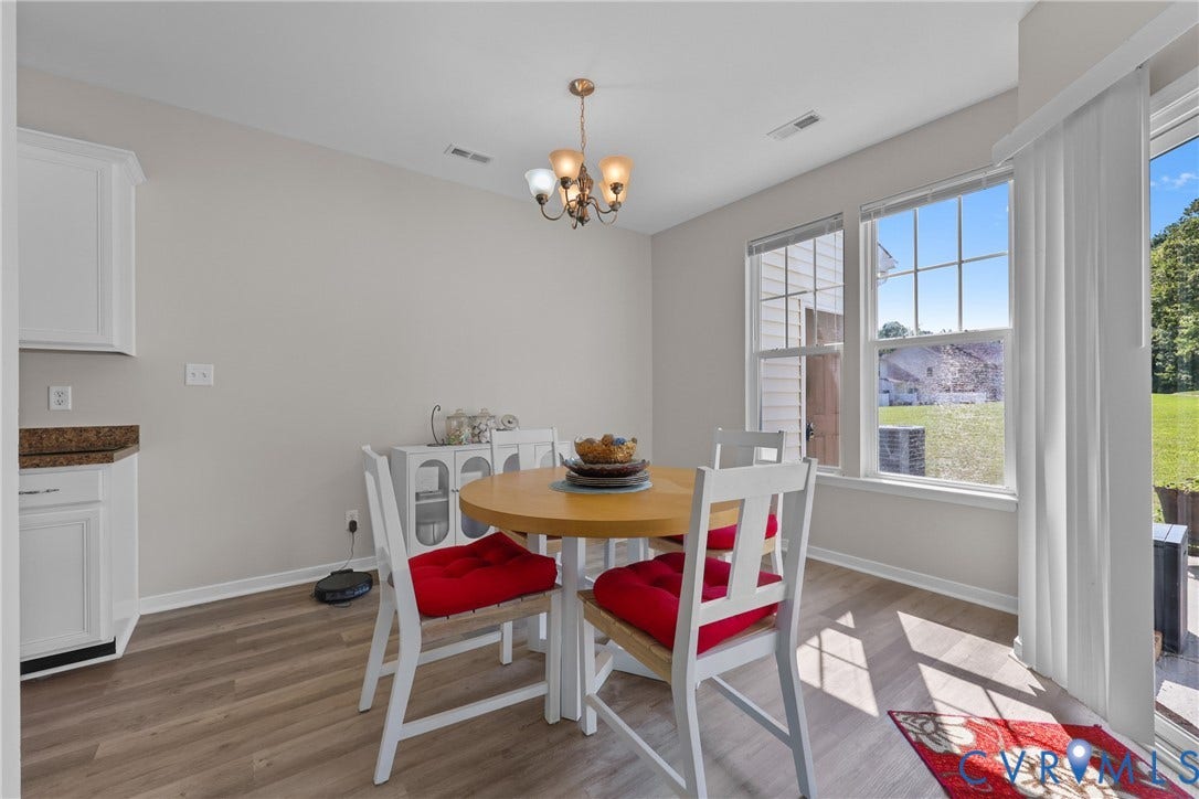 Wood-finish flooring, white cabinetry, and a sliding glass door to the exterior
