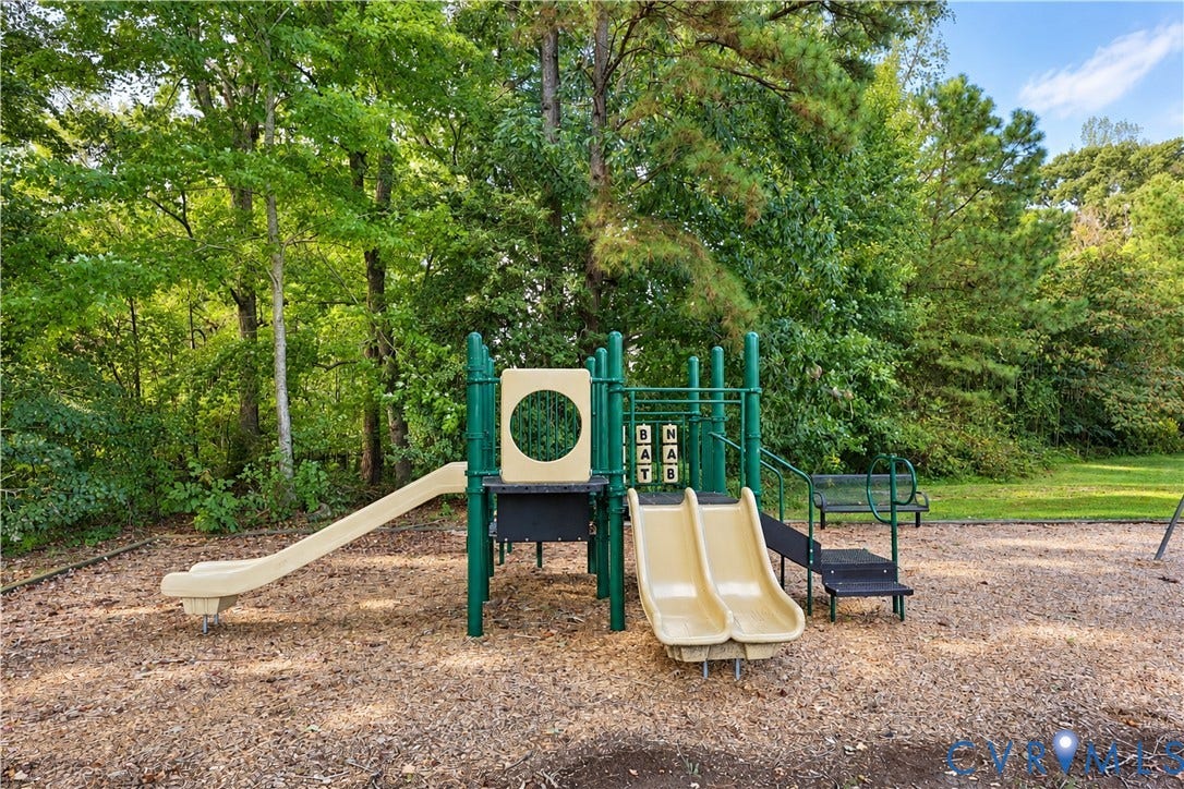 Outdoor play structure featuring two slides, stairs, and a climbing panel