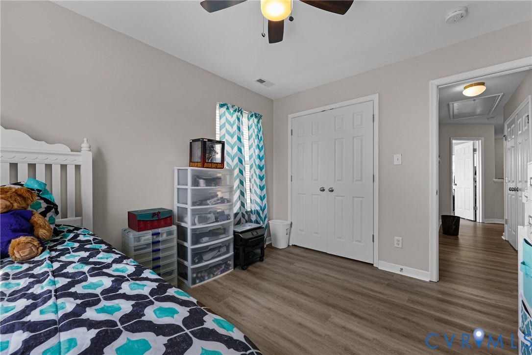Wood-finish flooring, neutral wall color, and a ceiling fan with integrated lighting