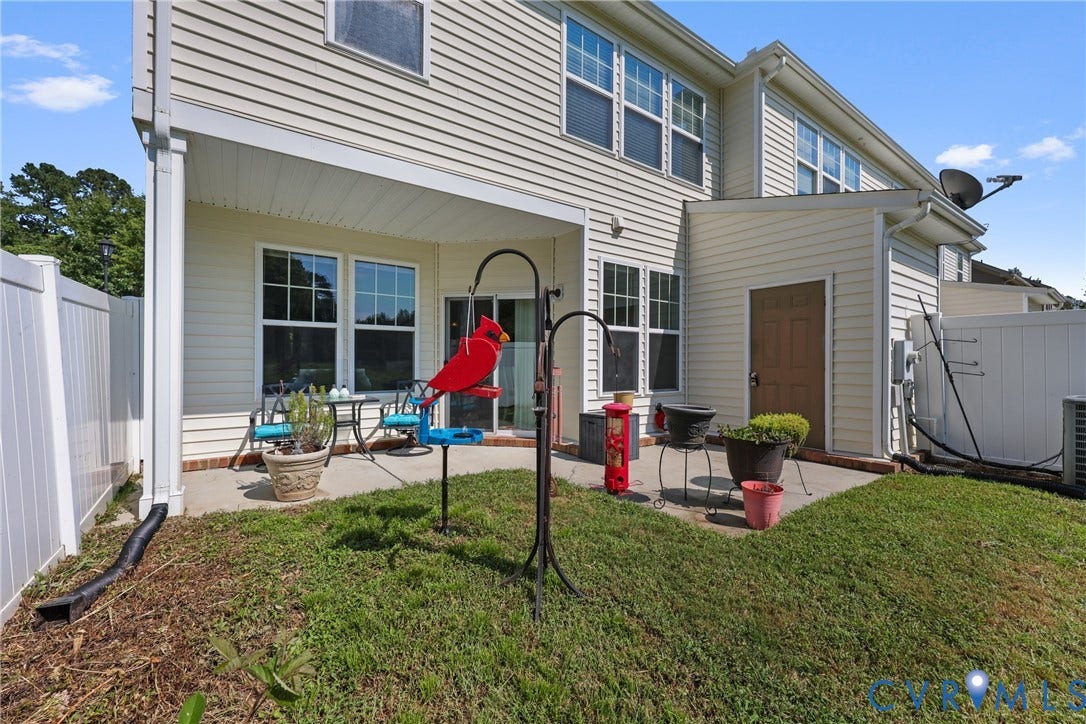 Rear patio with privacy fencing, covered outdoor area, and ground-level grass