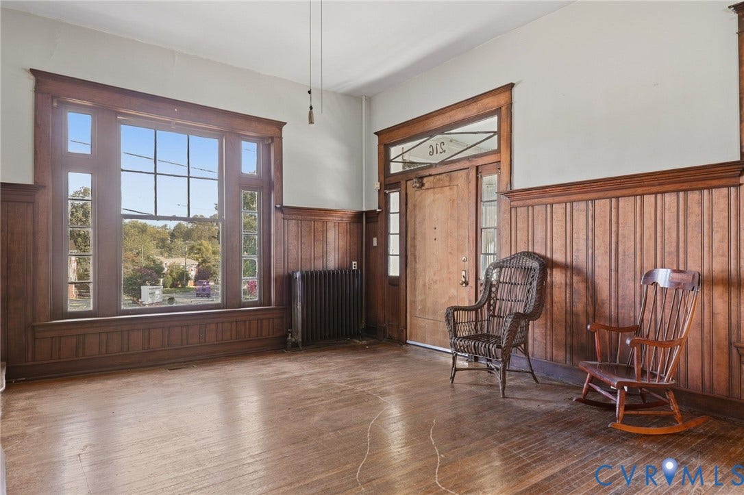 216 W Roanoke Street, Richmond, VA 23225 Hardwood flooring, wood paneling, decorative window trim, a prominent entry door with transom window, and a classic radiator