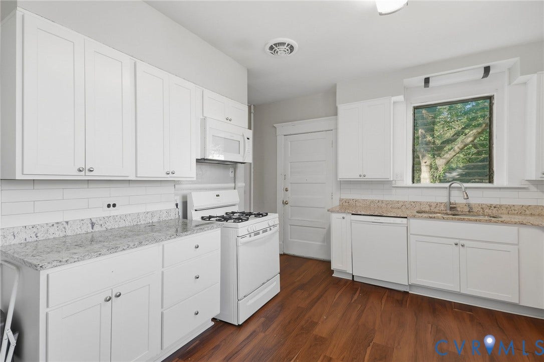 216 W Roanoke Street, Richmond, VA 23225 Kitchen featuring white cabinetry, light-toned countertops, a white subway tile backsplash, stainless steel sink, and wood-finish flooring
