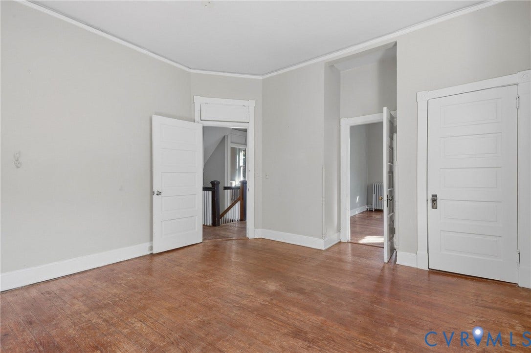 216 W Roanoke Street, Richmond, VA 23225 Wood-finish flooring with white trim, five-panel interior doors, and a staircase with dark wood newel post and balusters
