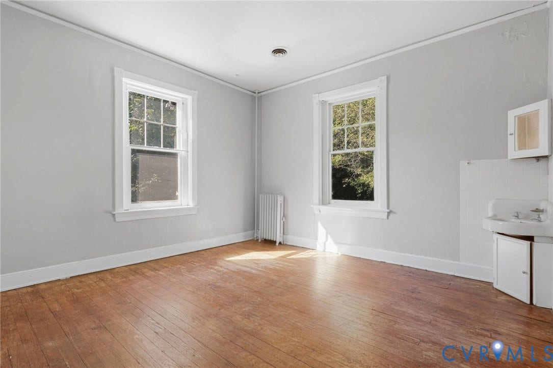 216 W Roanoke Street, Richmond, VA 23225 Hardwood flooring, two large windows, baseboard heating unit, wall-mounted sink, and cabinetry