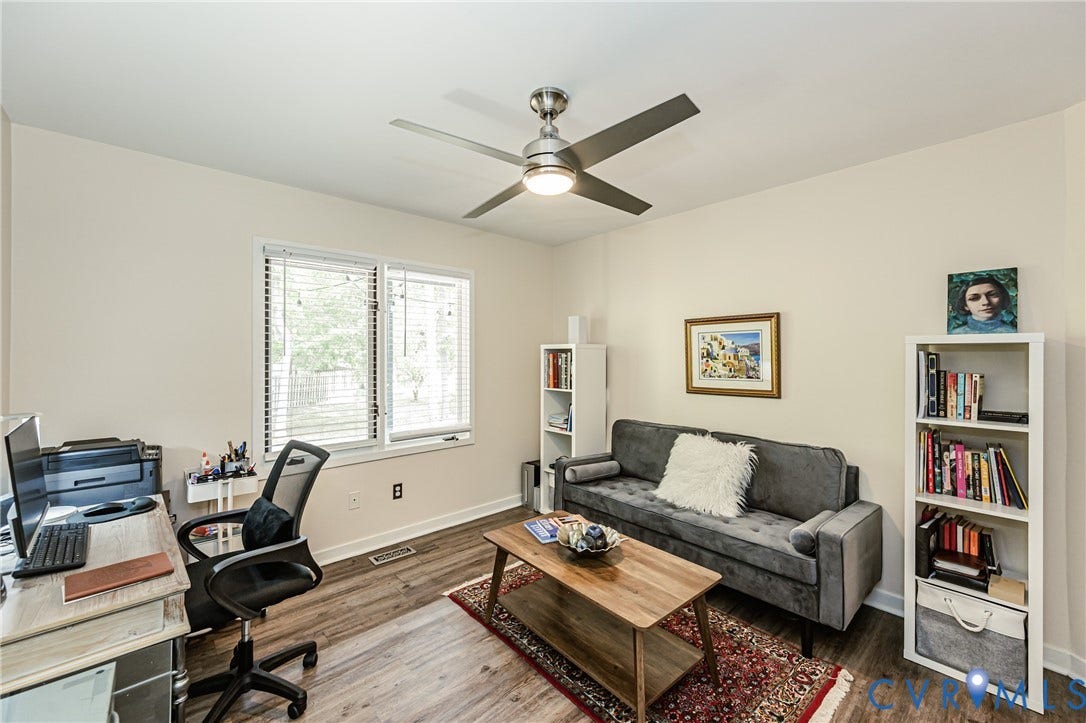 Wood-finish flooring, white trim, and a ceiling fan with integrated lighting