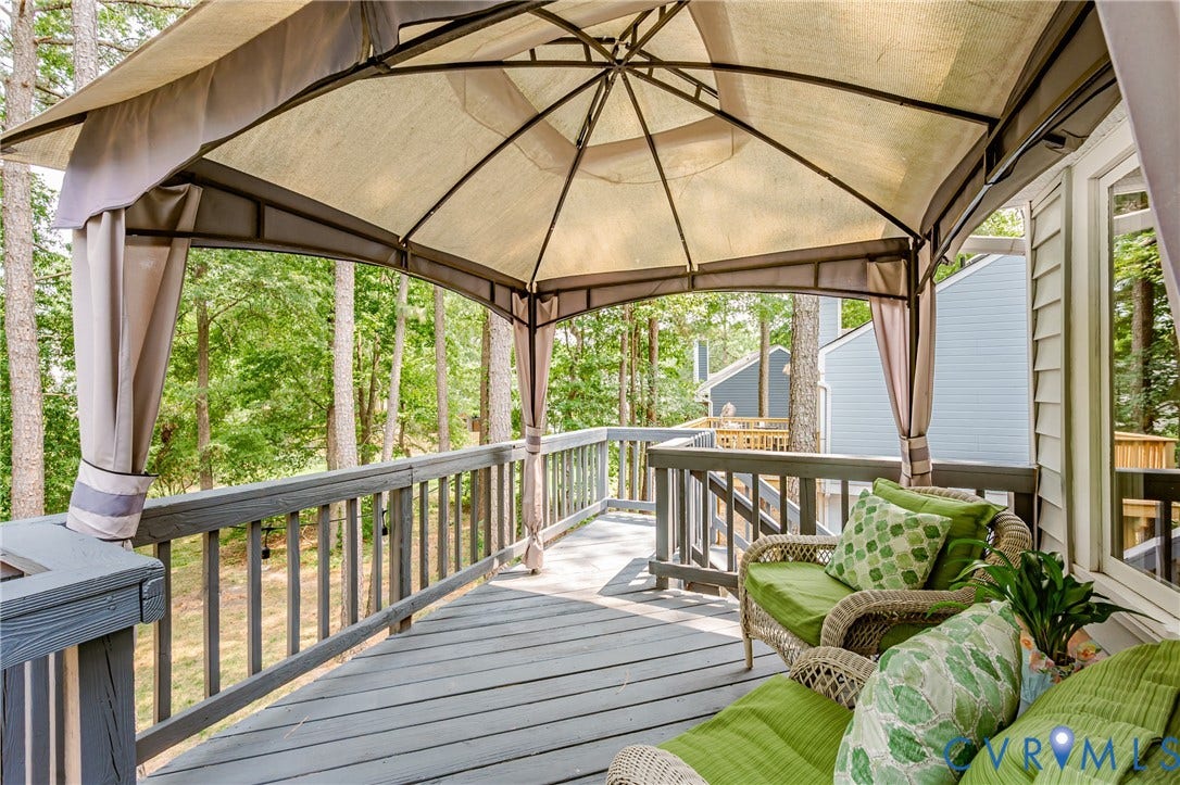 Expansive outdoor deck with a private gazebo structure and wood railing