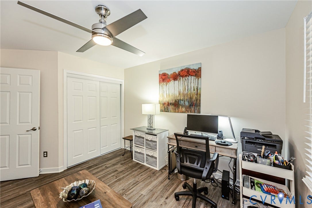 Neutral wall color with wood-finish flooring, white paneled doors, and a ceiling fan with integrated lighting