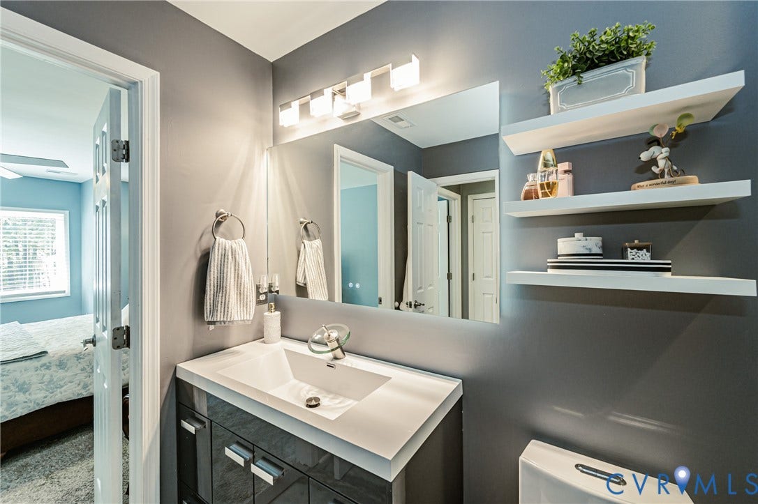 Vanity with an integrated rectangular basin, chrome faucet, and storage cabinetry