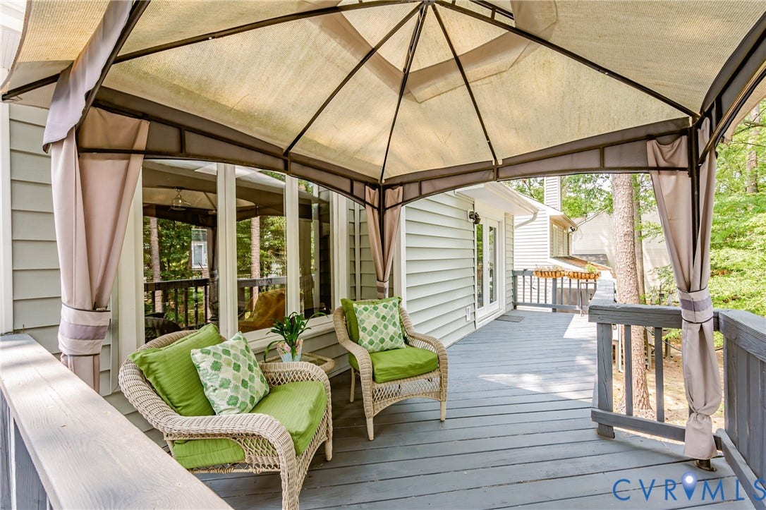 Expansive outdoor deck with a shaded gazebo, railing, and exterior wall siding