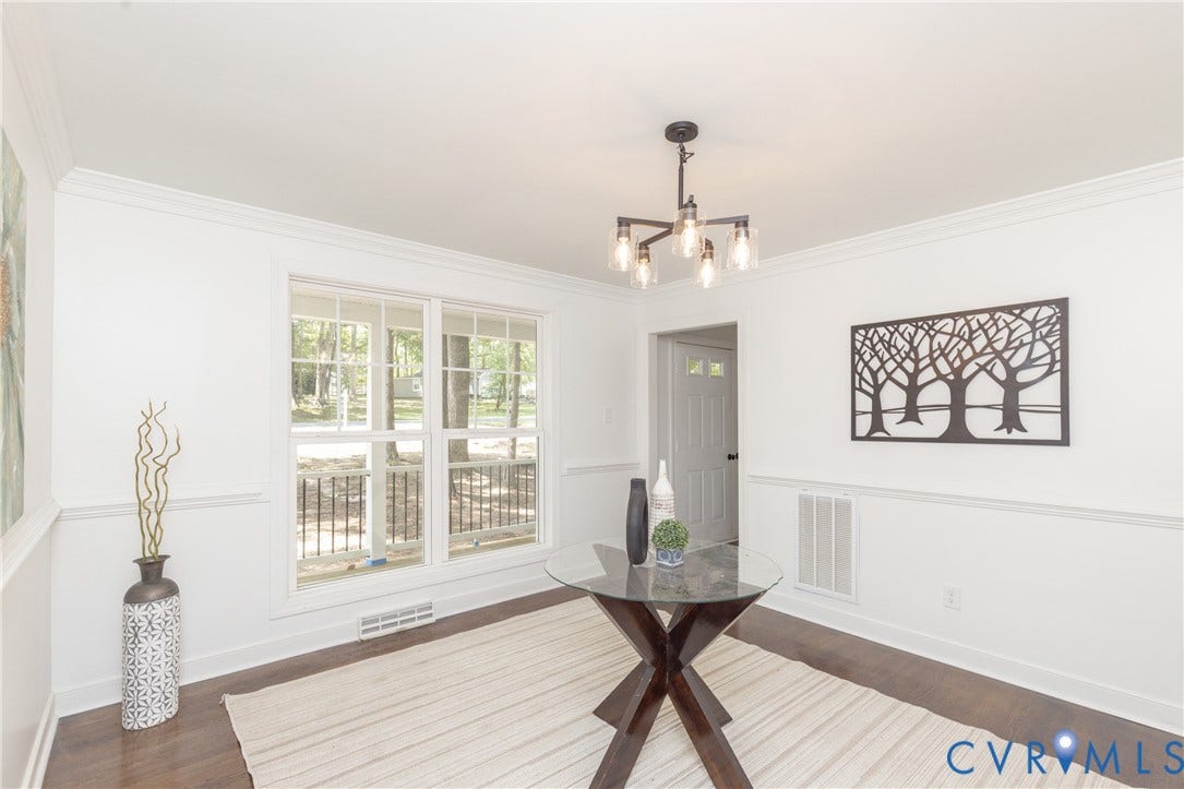 10541 Glencoe Road, Henrico, VA 23060 Crown molding, chair rail molding, large window, dark wood-finish flooring, and a modern chandelier