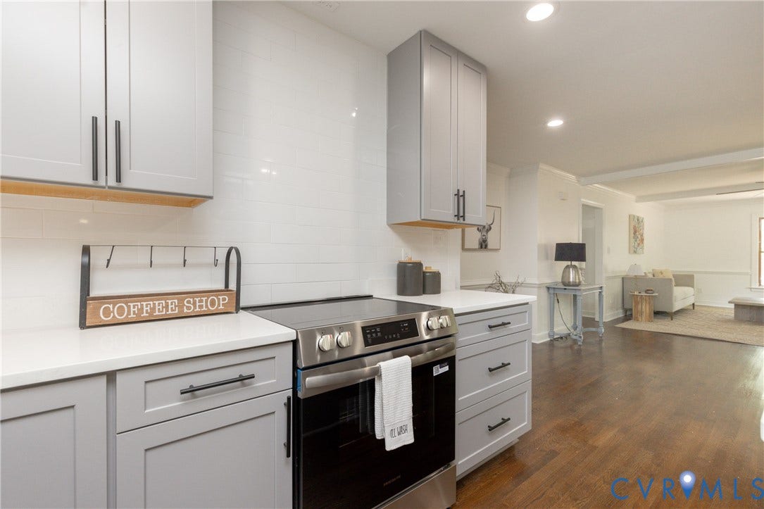 10541 Glencoe Road, Henrico, VA 23060 Light gray cabinetry with matte black hardware, white subway tile backsplash, stainless steel range, white countertops, and wood-finish flooring