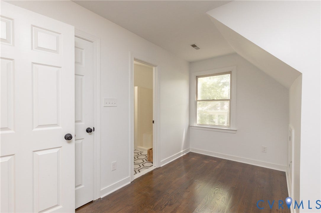 10541 Glencoe Road, Henrico, VA 23060 Hardwood flooring, white paneled doors with matte black hardware, and an angled ceiling feature a window with exterior views