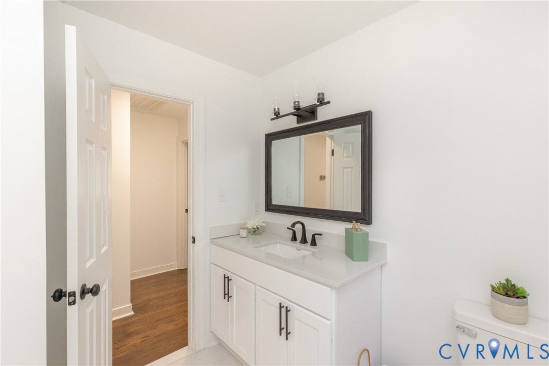10541 Glencoe Road, Henrico, VA 23060 White shaker vanity with black hardware, integrated sink, and light-toned countertop