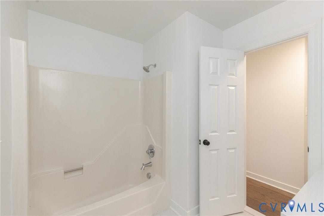 10541 Glencoe Road, Henrico, VA 23060 Bathtub with an integrated shower enclosure, chrome fixtures, and a white six-panel door