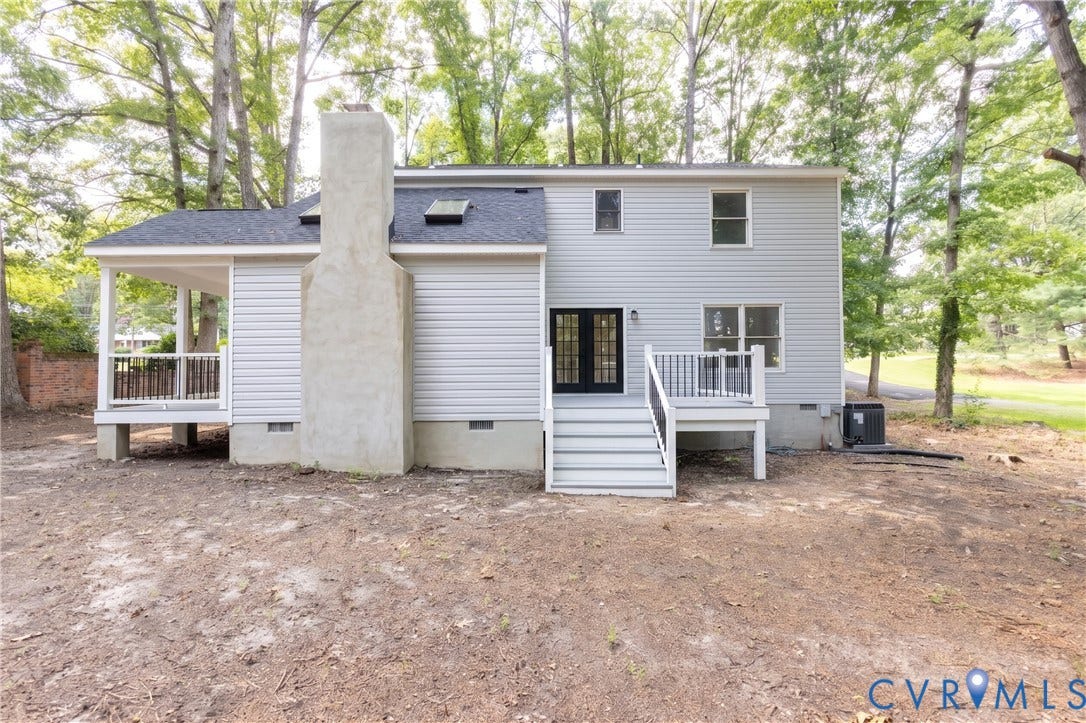 10541 Glencoe Road, Henrico, VA 23060 Rear elevation featuring light gray siding, a covered porch, a stone-clad chimney, a skylight, and a rear deck with black railings