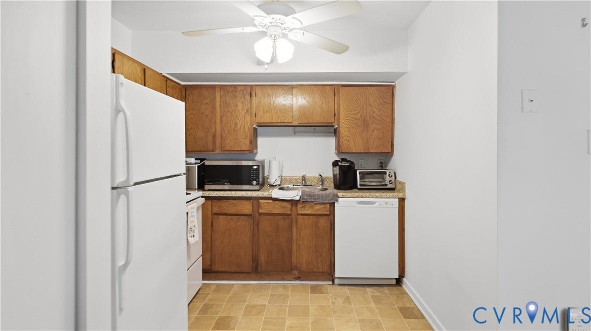 15253 Broadwater Circle, Chester, VA 23831 Kitchen featuring wood cabinetry, light-toned countertops, tile flooring, and a ceiling fan