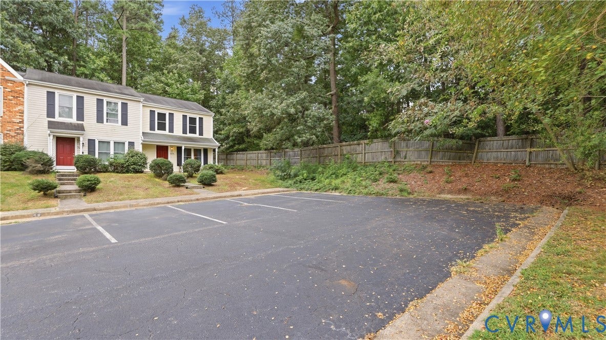 15253 Broadwater Circle, Chester, VA 23831 Two-story residential structure with light-colored siding, black louvered shutters, and red entry doors