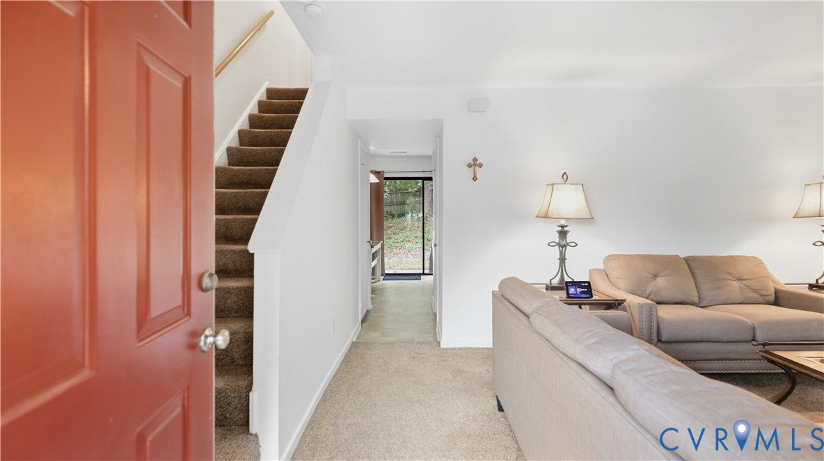 15253 Broadwater Circle, Chester, VA 23831 Carpeted stairs with wood handrail, paneled entry door with polished hardware, and carpeted flooring throughout the living space
