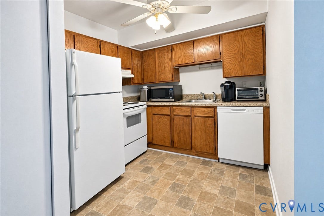 15253 Broadwater Circle, Chester, VA 23831 Kitchen featuring white appliances, wood cabinetry, laminate countertops, a ceiling fan, and patterned flooring