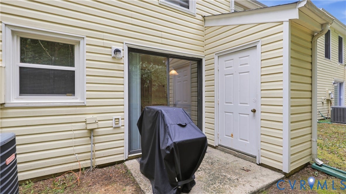 15253 Broadwater Circle, Chester, VA 23831 Concrete patio with a sliding glass door and an exterior utility door, featuring horizontal siding