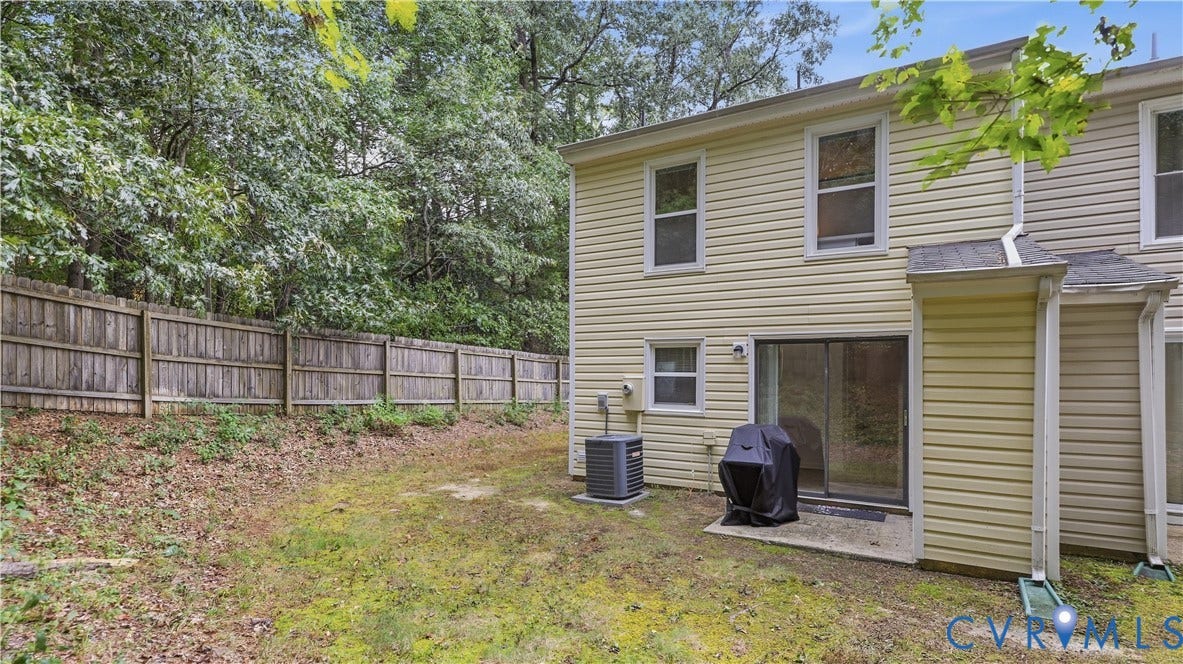 15253 Broadwater Circle, Chester, VA 23831 Rear exterior with a wood privacy fence, concrete patio, and sliding glass door access