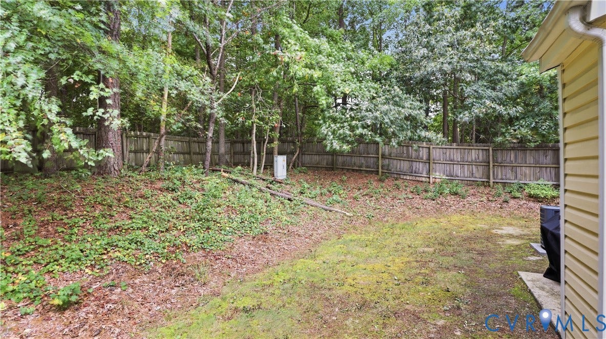 15253 Broadwater Circle, Chester, VA 23831 Expansive yard featuring a wooden privacy fence, mature trees, and a concrete patio
