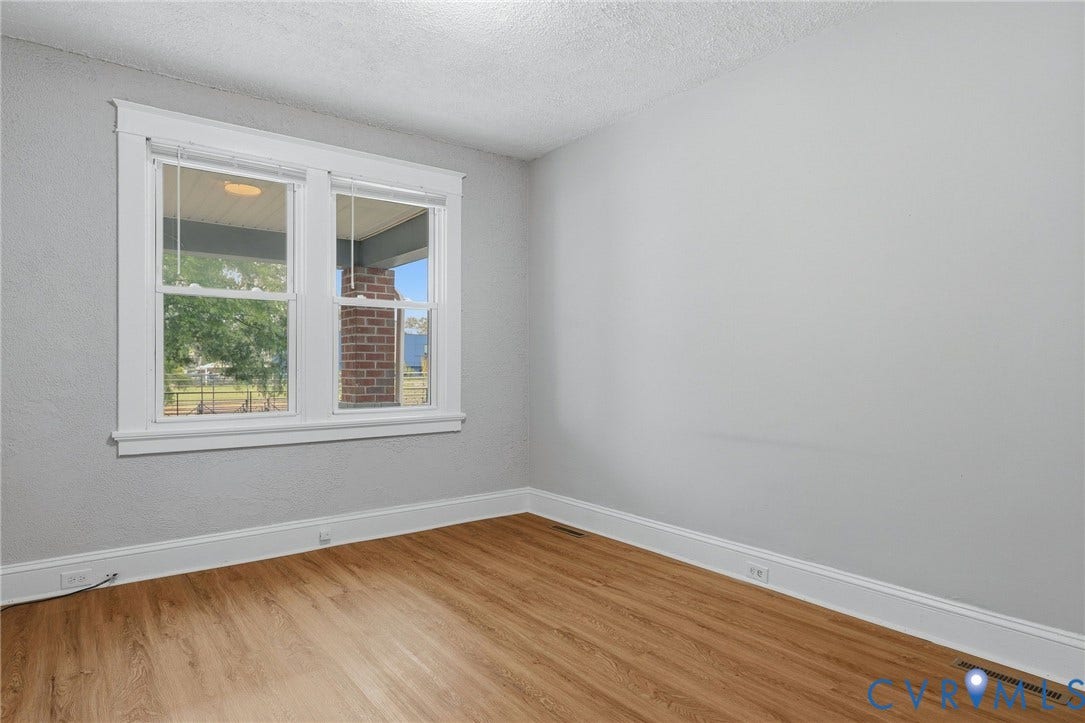 Wood-finish flooring, white trim, and light gray wall color