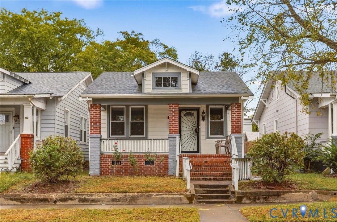 Craftsman-style home featuring a covered front porch, brick and siding exterior, and gabled dormer